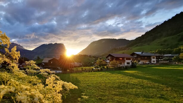 Ein ländliches Dorf mit Häusern und Bergen im Hintergrund.
