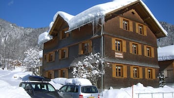 A multi-story hotel with a wooden facade and snow-covered roof.