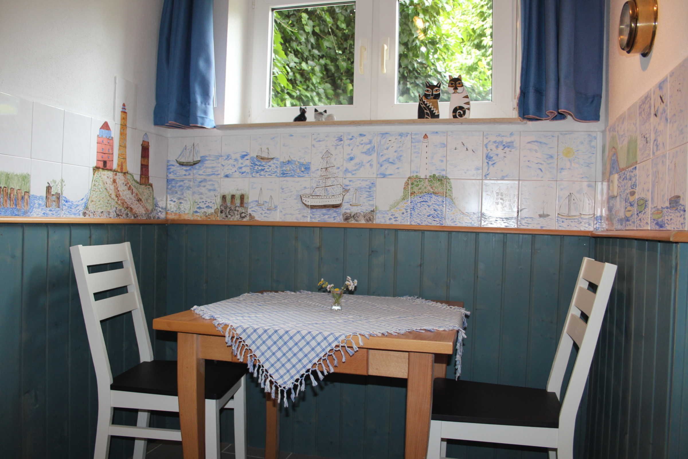 A dining area with a table, chairs, and a window with curtains.