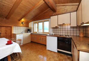 Eine Küche mit Holzausstattung, einem Herd, einer Spüle und einem Fenster.