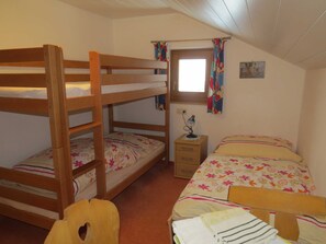 A bunk bed room with a window, a desk, and a chair. - Apartment 1 - Biohof Haus Wieser (Abtenau)