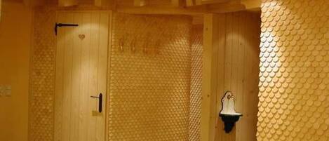 A room with wooden doors, a textured wall, and a small sink.