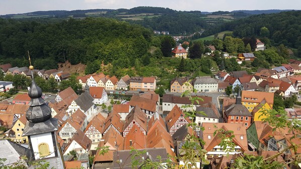 A town with traditional half-timbered houses, a church with a distinctive spire, and a river in the background. - Apartment Gold - Ferienhof Gold (Waischenfeld)