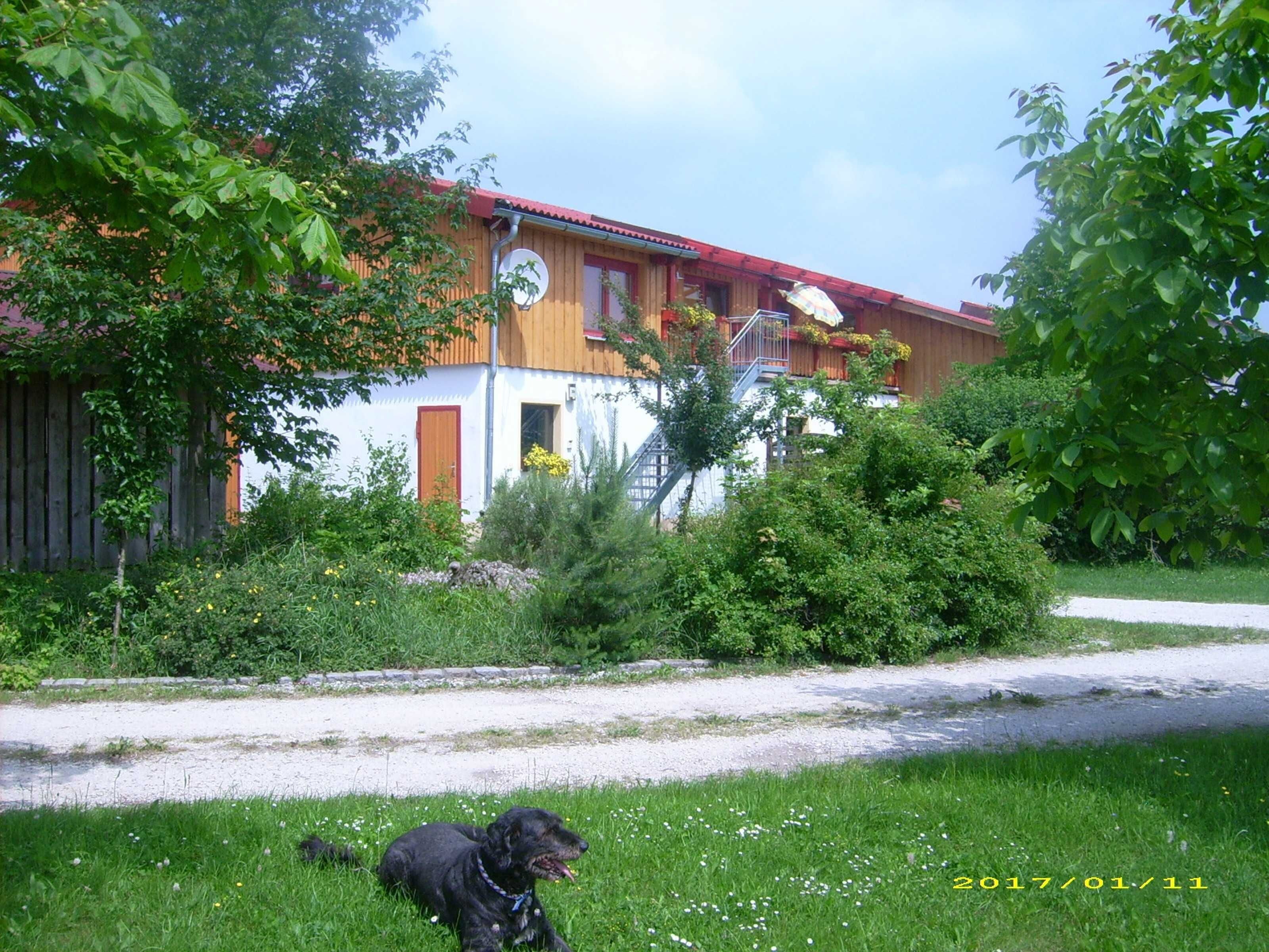 A building with a red roof, a wooden facade, and a visible satellite dish.