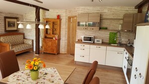 A compact living space with a dining area, kitchen, and a sofa.