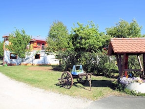 A rural setting with a house, a cart, and a small structure. - Apartment Gold - Ferienhof Gold (Waischenfeld)