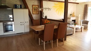 A kitchen with a built-in oven, a dining table with chairs, and a fireplace.