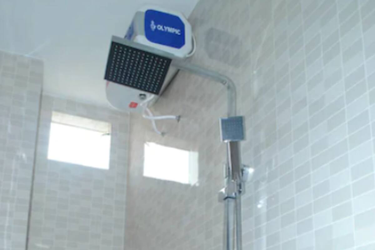 A bathroom with a shower, toilet, and a window.