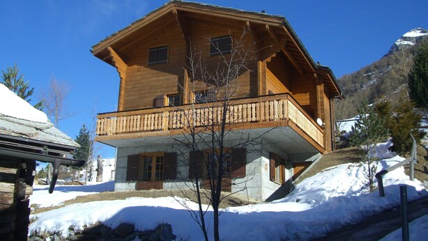 A wooden chalet with a balcony, surrounded by snow and mountains. - Chalet Blettner, Switzerland (Randa VS)