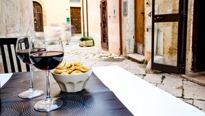 Ein Tisch mit zwei Weingläsern und einer Schale mit Snacks im Freien.