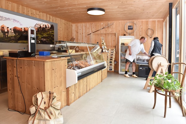 A wooden interior with a counter, a display case, and a large window.
