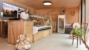 Un interior de madera con mostrador, refrigerador y una silla con plantas.