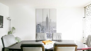 Un área de comedor con vistas a la ciudad, un tablero de ajedrez y una planta.