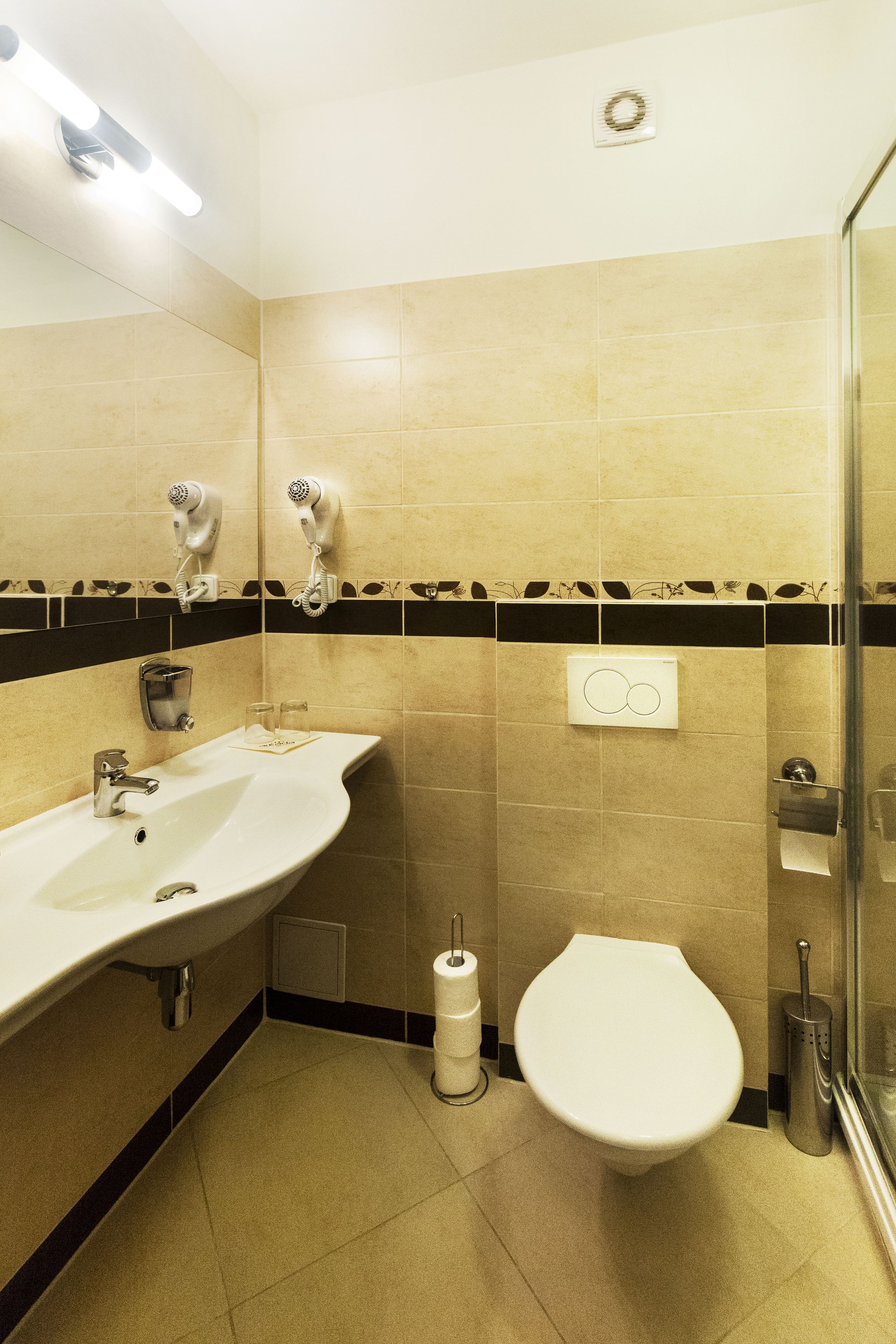 Une salle de bain équipée d’un lavabo, de toilettes et d’un sèche-mains.