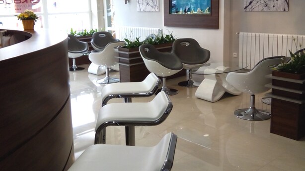 Een moderne lobby met meerdere zithoeken, een receptiebalie en decoratieve wandkunst.
