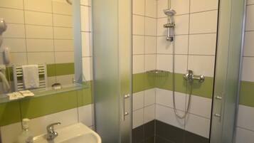 Une salle de bain avec une douche à parois de verre, un lavabo et un miroir.