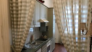 Eine kleine Küche mit Waschmaschine, Mikrowelle und Spüle.