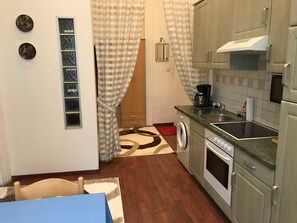 Una cocina compacta con lavadora, cafetera y horno empotrado.