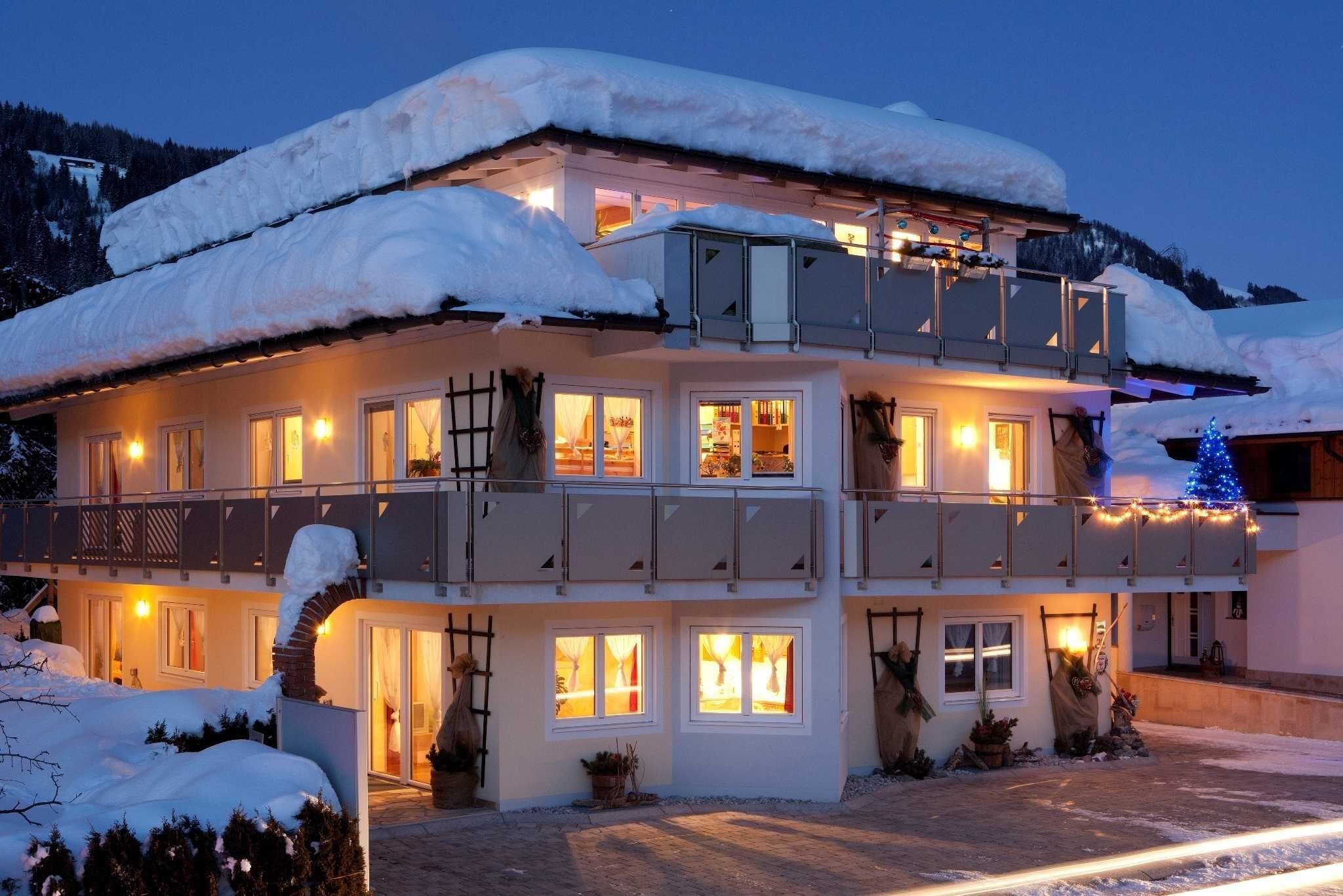 A two-story building with multiple windows and balconies, surrounded by snow.