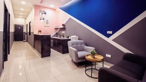 A modern hotel lobby with a reception desk, seating area, and a counter. - Jenjarom Boutique Hotel (Jenjarom)