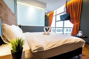 A hotel room with a bed, a potted plant, a flat-screen TV, and a window with curtains. - Jenjarom Boutique Hotel (Jenjarom)