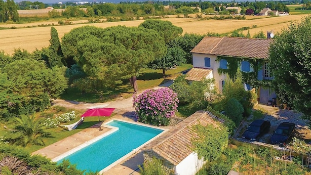 A villa with a swimming pool, surrounded by lush greenery and a vineyard in the background. - Beautiful home in Caderousse (Caderousse)