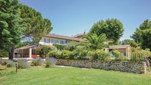 A two-story house with a stone wall and a covered patio area. - Beautiful home in Caderousse (Caderousse)