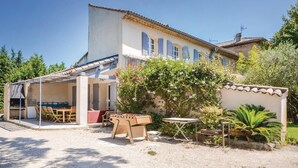 A two-story house with a covered patio area, outdoor seating, and a small garden. - Beautiful home in Caderousse (Caderousse)