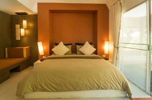 Un dormitorio con una cama grande, dos lámparas de noche, un banco y vistas al exterior.