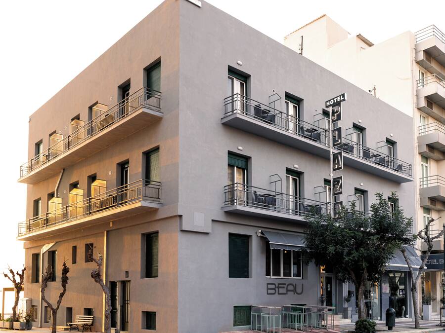 A multi-story hotel with balconies, a visible 'HOTEL' sign, and a 'BEAU' sign on the facade.