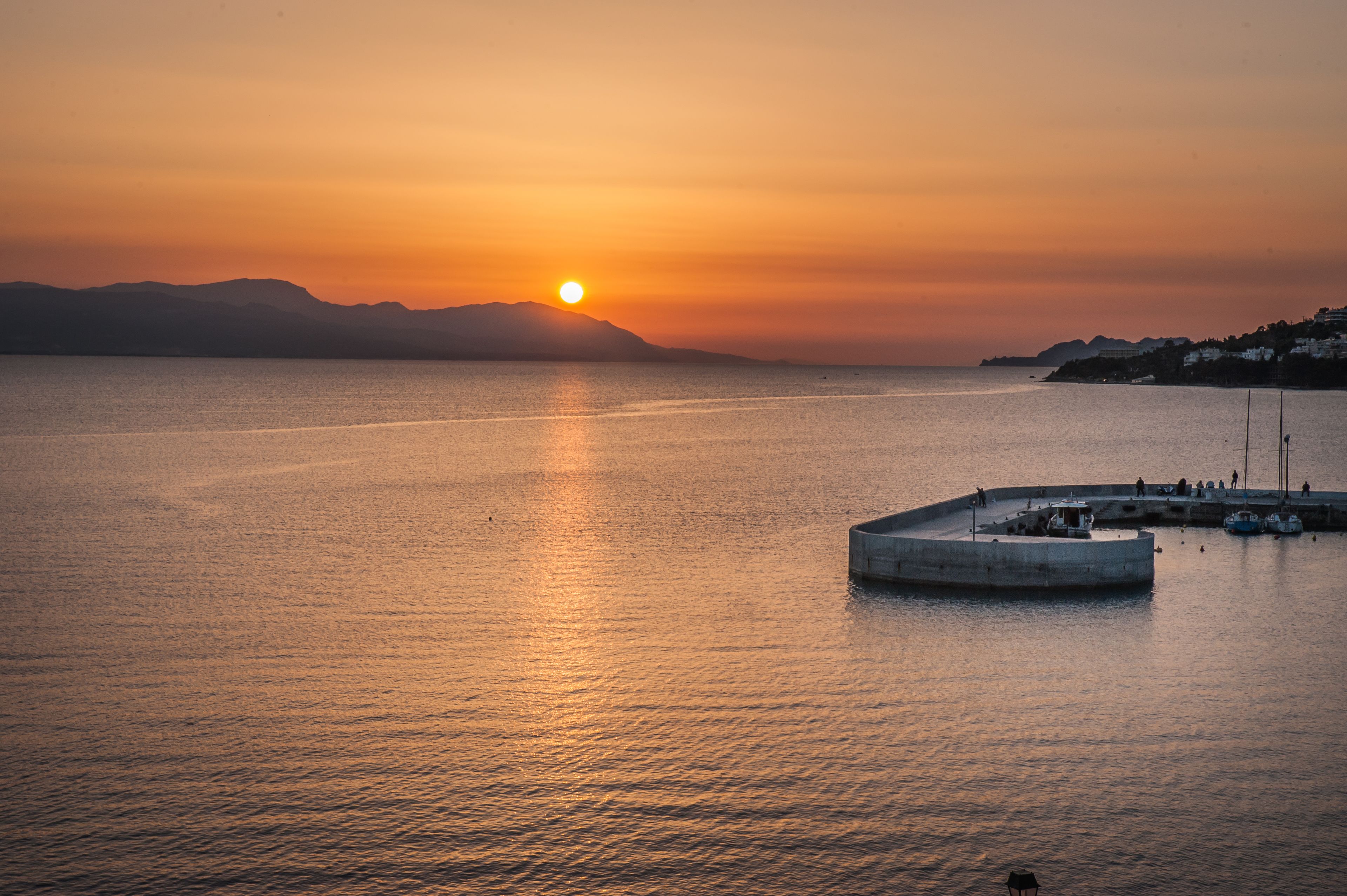 A coastal sunset view with a marina and boats.