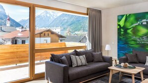 A modern living room with a large window, a sofa, a coffee table, and a painting. - Holztau, Pfunds, Austria (Pfunds)