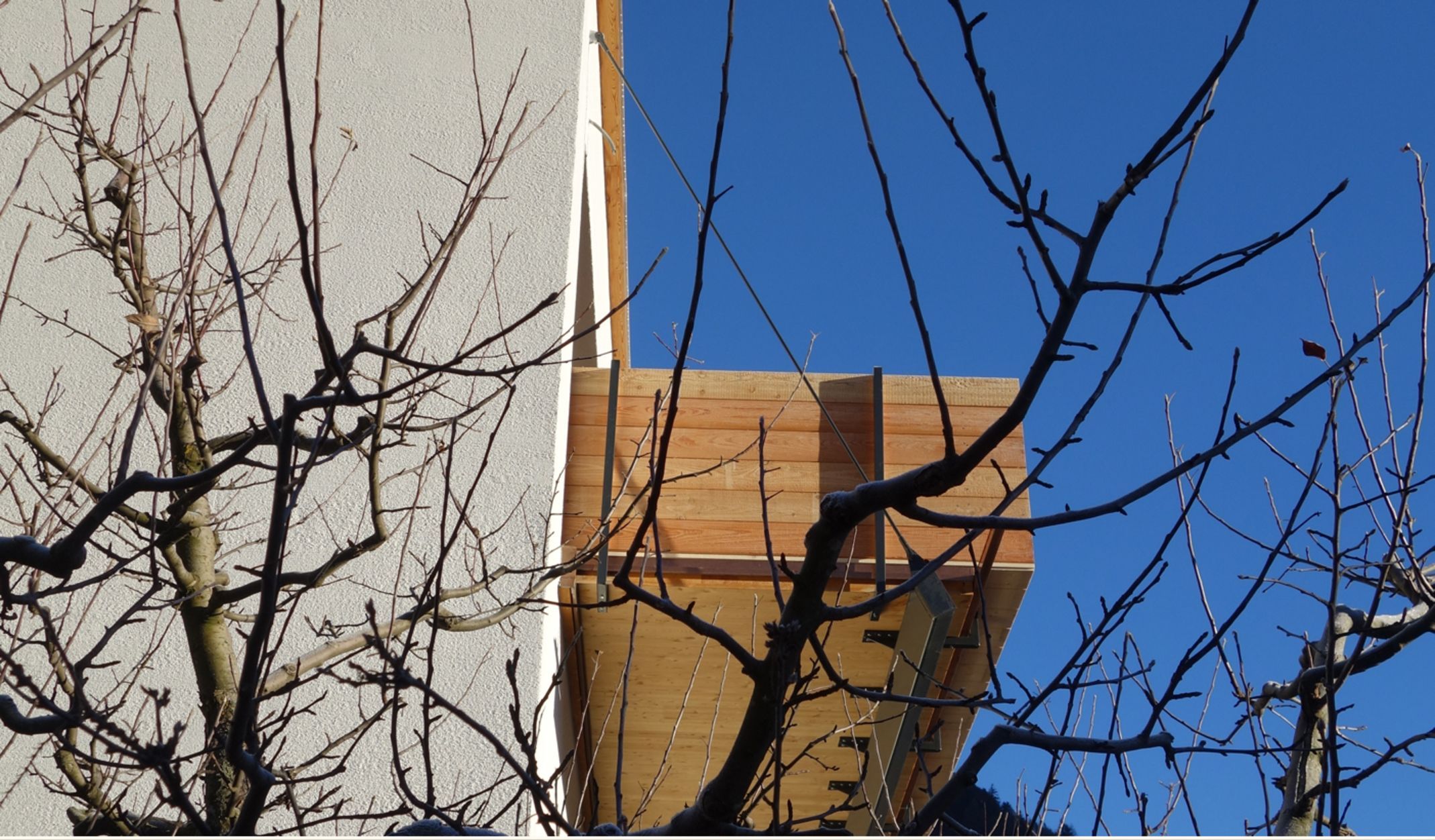 A building with a wooden facade and a clear blue sky in the background.