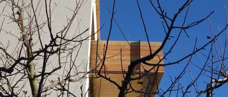 Un bâtiment à la façade en bois, avec un ciel bleu clair en arrière-plan.