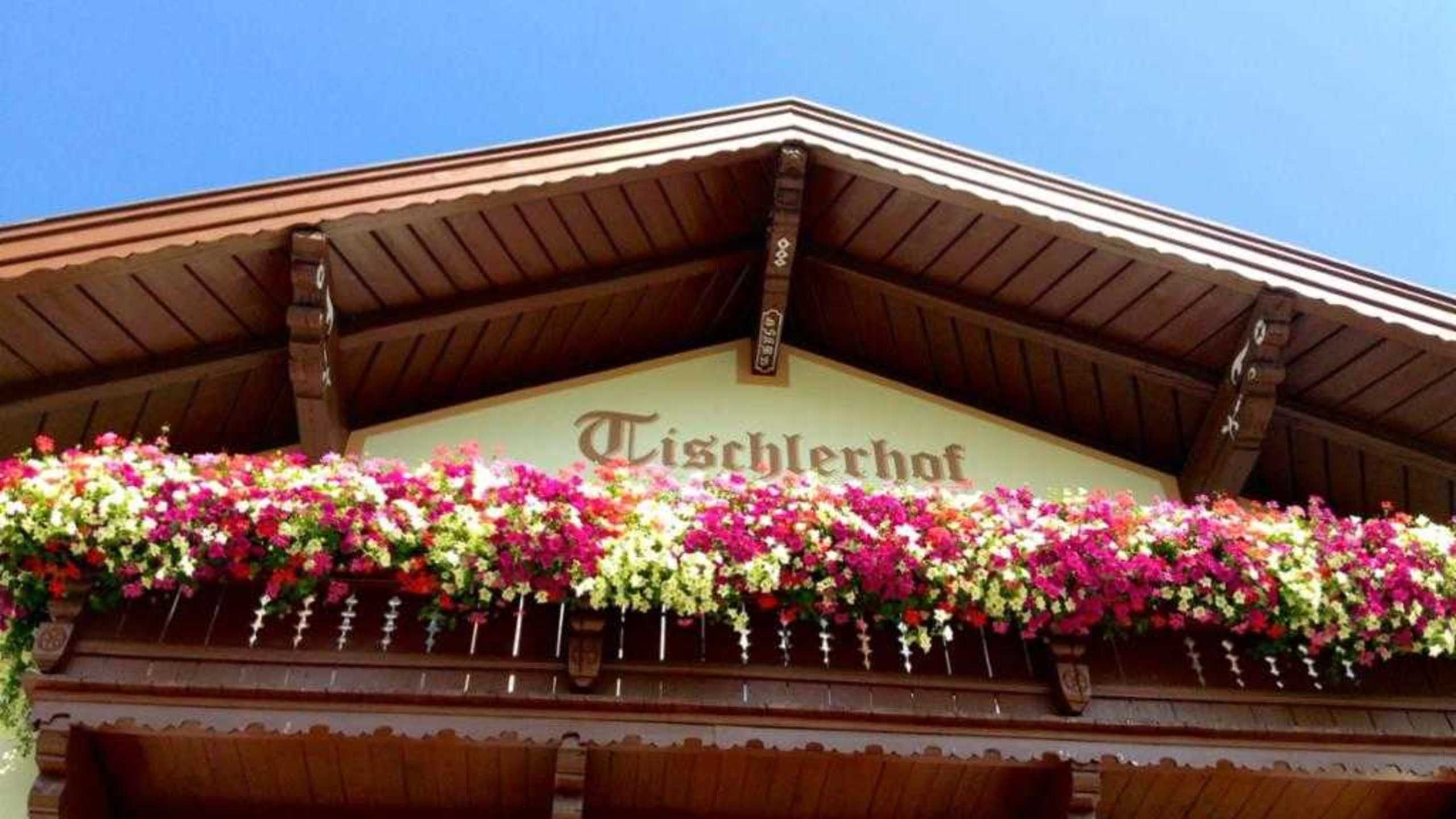 Un bâtiment portant une enseigne indiquant « Tischlerhof » et dont la façade est recouverte de fleurs.