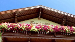 A building with a sign reading 'Tischlerhof' and a flower-covered facade.