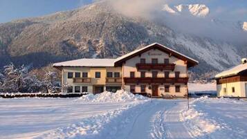 Un bâtiment recouvert de neige, avec une montagne en arrière-plan.