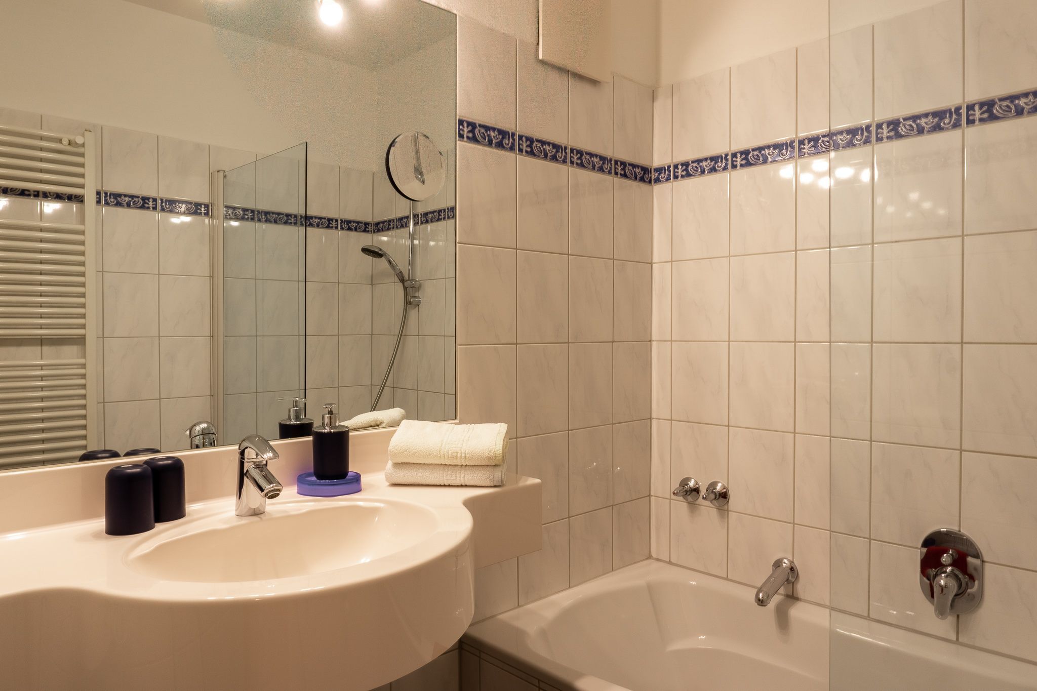 Ein Badezimmer mit Waschbecken, Spiegel und Badewanne.
