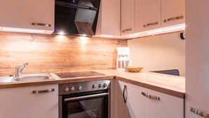 Een moderne keuken met een houten aanrecht, roestvrijstalen apparatuur en een koffiezetapparaat.