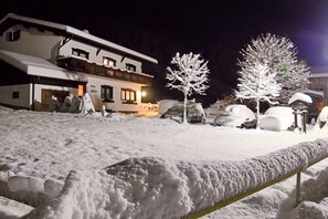 A snow-covered landscape with a building featuring balconies and a sign that reads 'Hotel.' - Künzelspitze DZ#2 - Ritter Anni - Haus Ritter (Schoppernau)