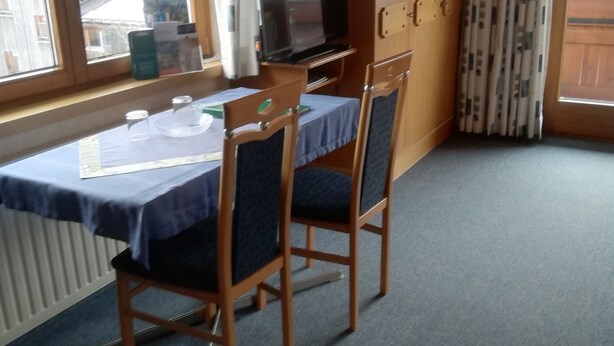A room with a table, chairs, a television, and a wardrobe. - Künzelspitze DZ#2 - Ritter Anni - Haus Ritter (Schoppernau)