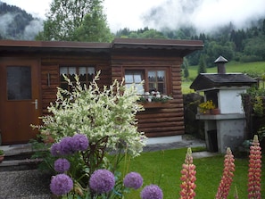 A log cabin with a wooden door, windows, and a small chimney.