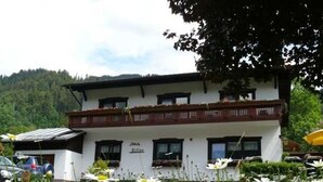 A white building with a balcony, surrounded by a field of daisies. - Künzelspitze DZ#2 - Ritter Anni - Haus Ritter (Schoppernau)