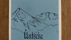 Una tarjeta con un paisaje montañoso y la palabra 'Untsche' escrita en ella.