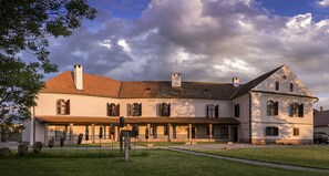 Un bâtiment historique à la façade symétrique, doté de nombreuses fenêtres et d’une entrée centrale.