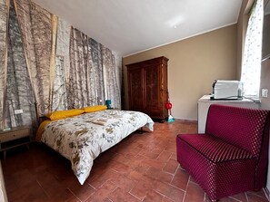 Un dormitorio con cama, armario de madera, una silla roja y una ventana con cortinas.
