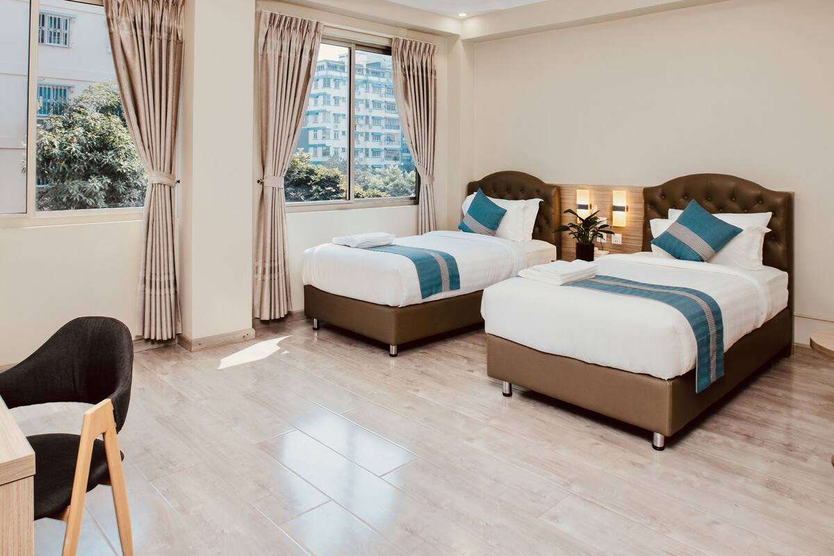 Una habitación de hotel con dos camas, un escritorio y una silla.