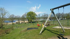 A park with a swing set, a bench, and a playground. - Apartment 01 in the fisherman's house with terrace - Apartment Fischers Fritze with winter garden and (Sellin)