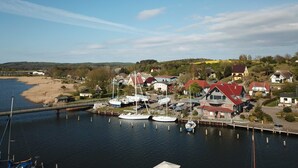 A marina with boats docked, a bridge, and houses with red roofs. - Apartment 01 in the fisherman's house with terrace - Apartment Fischers Fritze with winter garden and (Sellin)