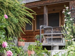 A wooden cabin with a porch, a window, and a number '168' on the wall.